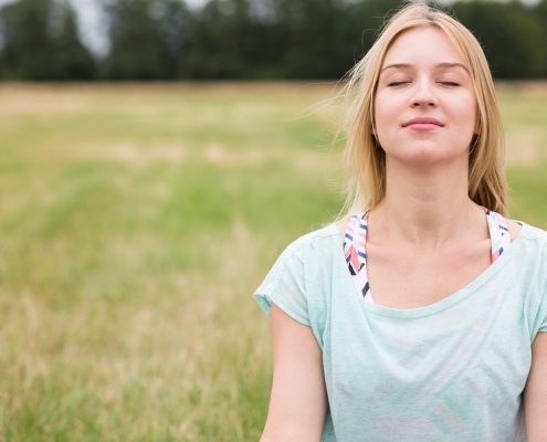 Young woman with closed eyes experiencing harmony with nature