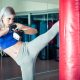 Woman Hits The Heavy Bag With A Strong Kick