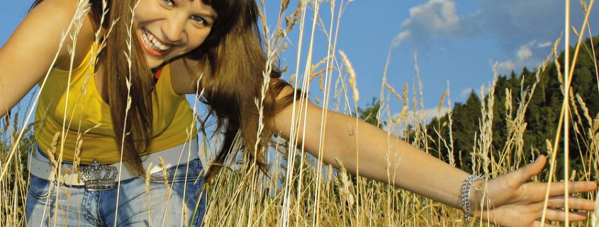 girl in high grass on a sunny day.